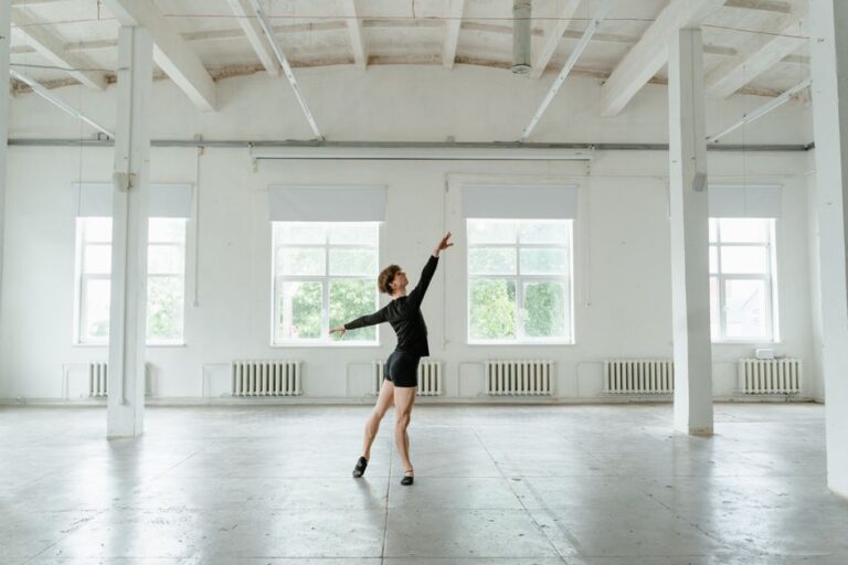 A child practicing dance steps in a tidy living room, with sunlight, a wood floor, and a mirror in the background.
