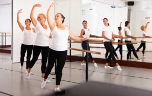 Young dancer sits beside a studio mirror while reviewing notes after an audition.